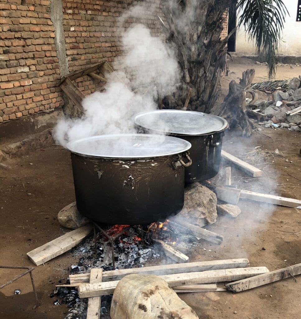 Two pots on a stove, emitting smoke as they heat over an open flame, creating a dynamic cooking scene.